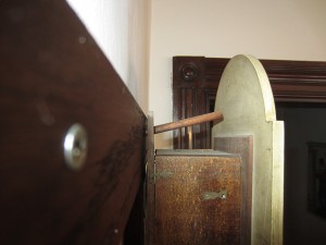 Clock back, hanging on an angled dowel.
